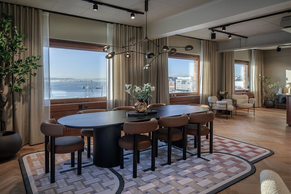 Et rom med vinduer og bord og stoler